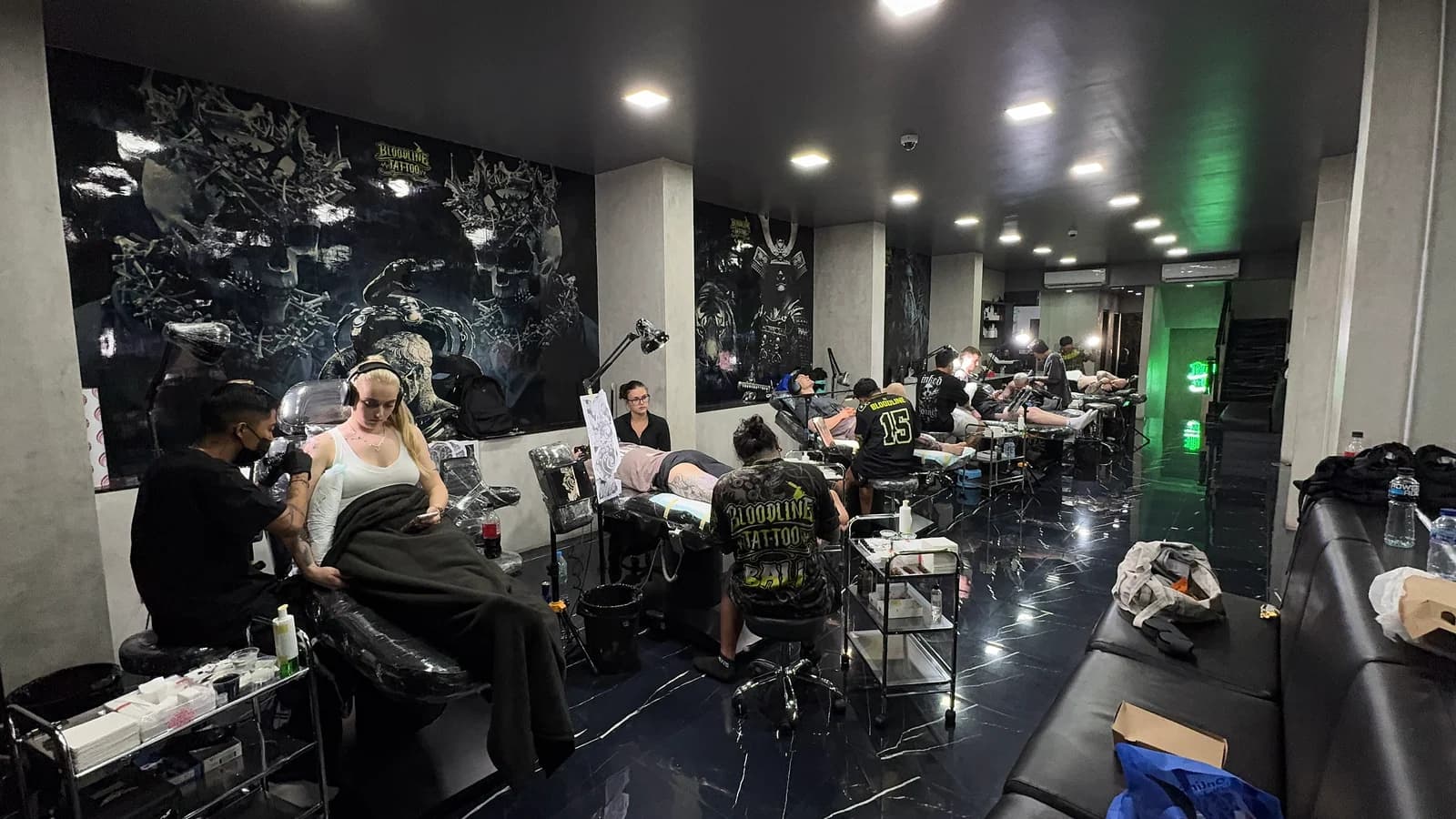 Bloodline Tattoo Bali studio floor with artists at work and Bloodline Bali branding