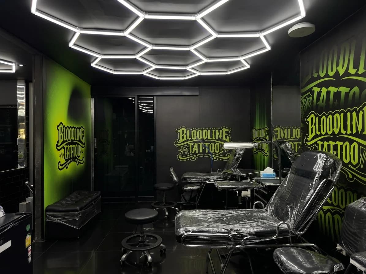 Bloodline Tattoo Phuket studio floor with neon branding and hexagonal ceiling lights