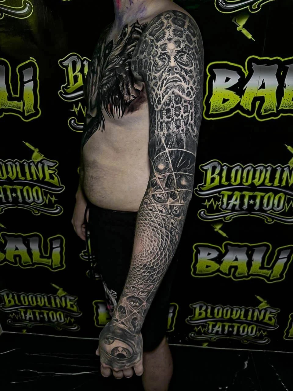 Healed surreal sleeve with all-seeing eyes, lattice geometry, and face-like patterning, showing clean healed gradients and crisp line integrity at Bloodline Tattoo Bali.