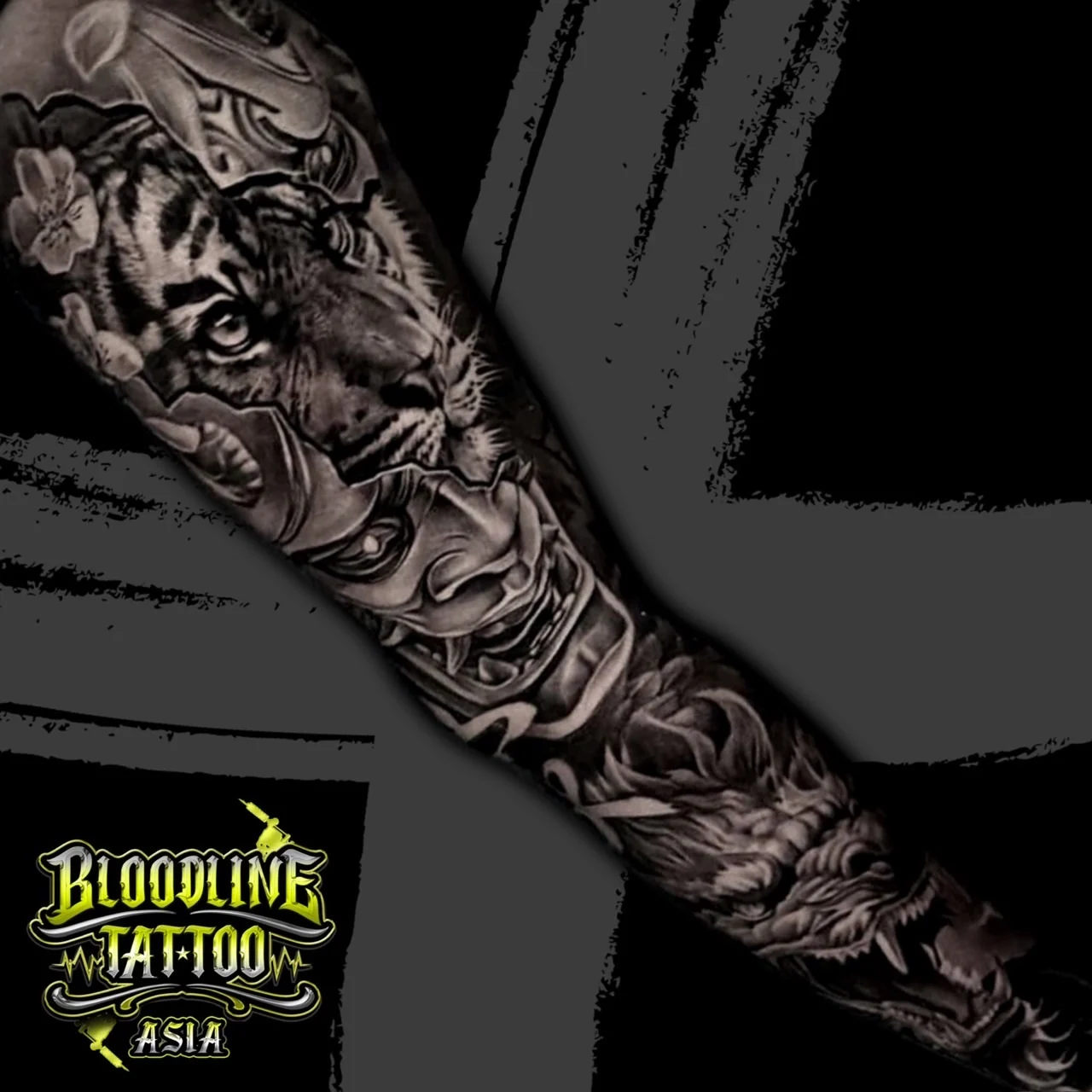 Black and grey Japanese full sleeve with tiger, Hannya mask, dragon head, and sakura among wind bars at Bloodline Tattoo Bangkok.