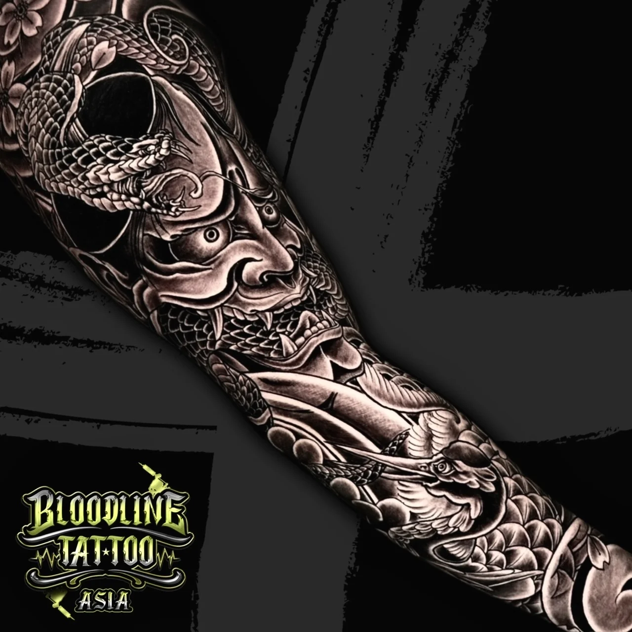 Black and grey Japanese sleeve with Hannya mask, coiled snake, crane, cherry blossoms, and clouds at Bloodline Tattoo Bangkok.
